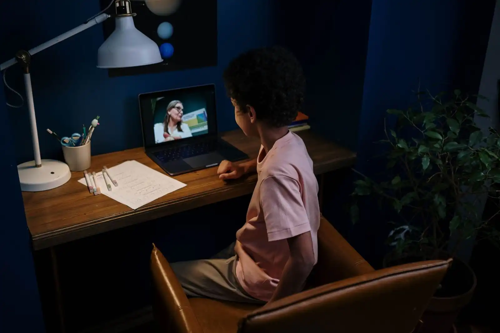 A young boy learning online with a laptop at home