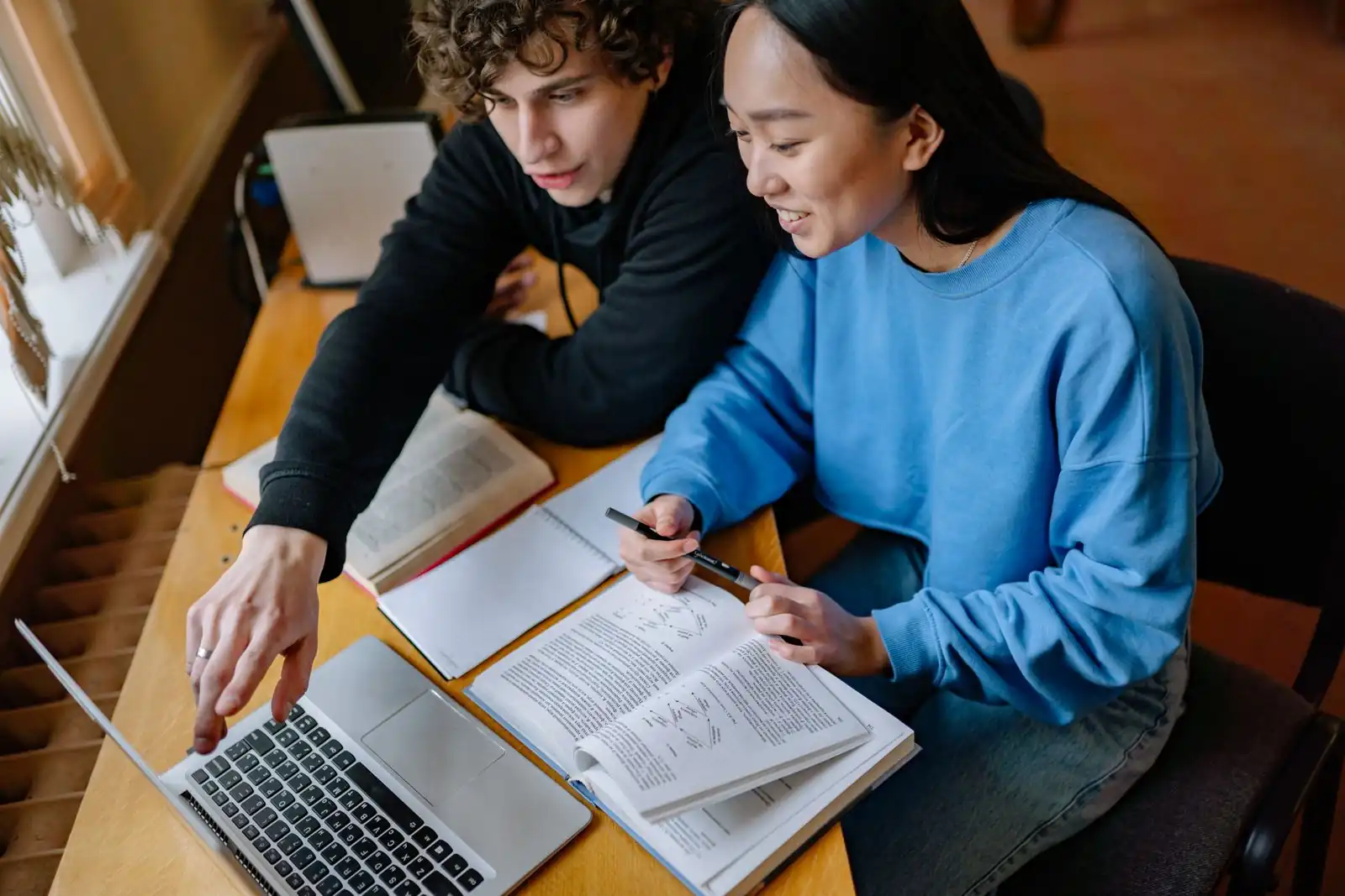 Two students working through their notes together at a desk